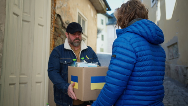 Volunteers collecting boxes with Humanitarian aid for the Ukrainian immigrants in street.