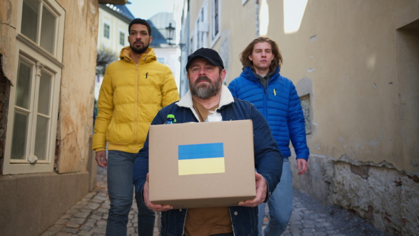 The team of volunteers collecting boxes with Humanitarian aid for Ukrainian refugees in street