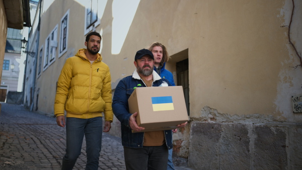 The team of volunteers collecting boxes with Humanitarian aid for Ukrainian refugees in street