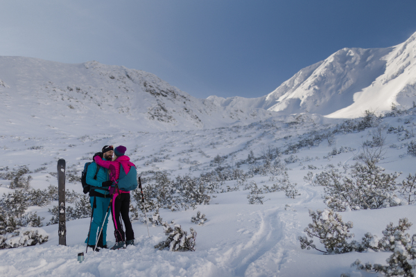 A ski touring couple in love taking break on the top of mountain in the Low Tatras in Slovakia.