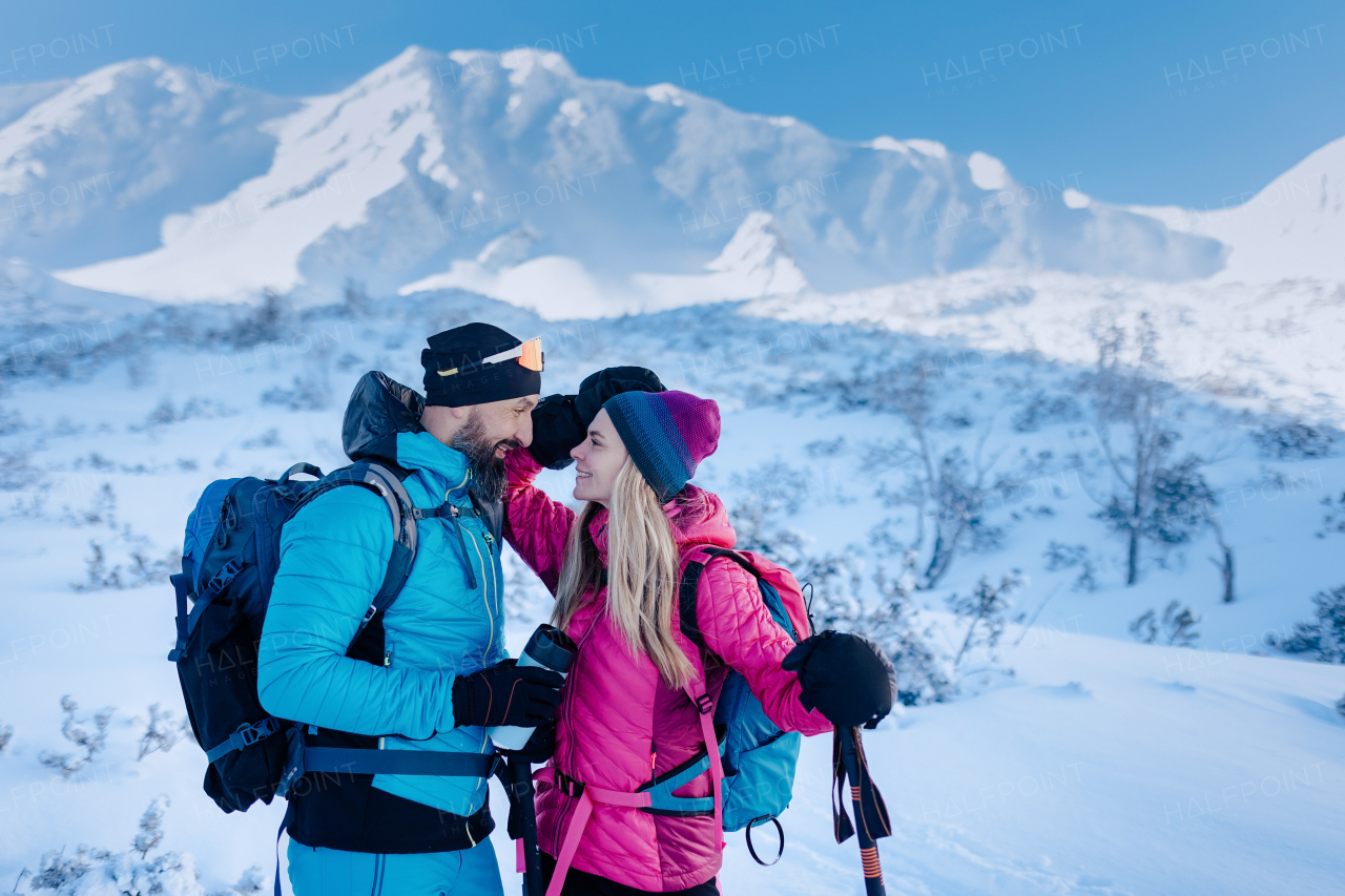 A ski touring couple in love taking break on the top of mountain in the Low Tatras in Slovakia.