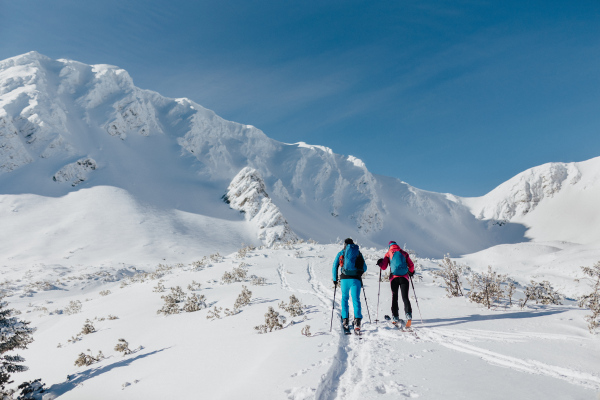 A rear view of ski touring couple hiking up a in the Low Tatras in Slovakia.