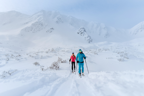 A front view of ski touring couple hiking up a mountain in the Low Tatras in Slovakia.