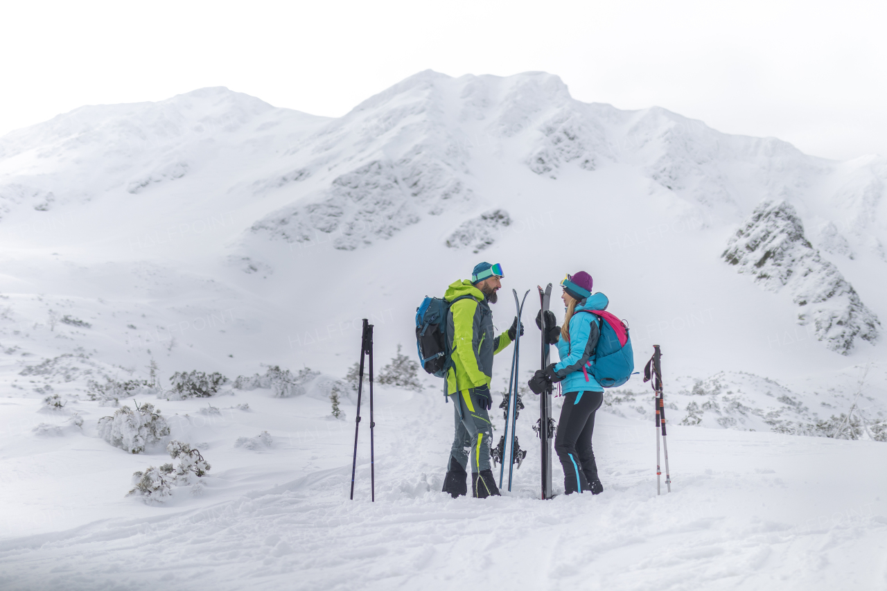 A ski touring couple taking break on the top of mountain in the Low Tatras in Slovakia.