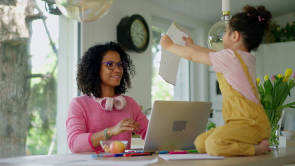 A Mother working from home while child is drawing picture. Home office concept.