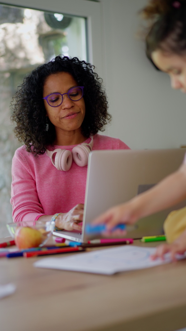 A Mother working from home while child is drawing picture. Home office concept.