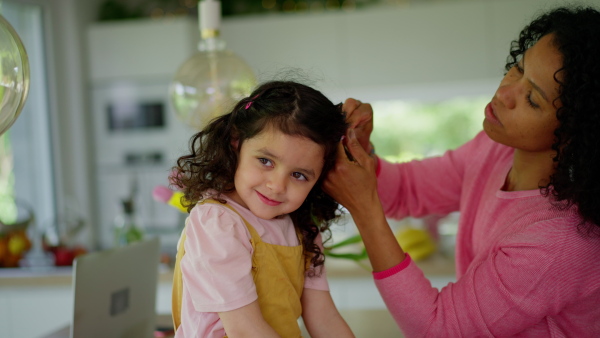 A mother is making daughter's hair style, morning routine concept.