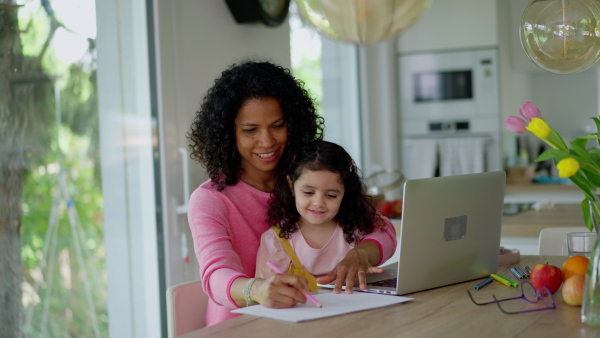 A mother working from home while child is sitting with her. Home office concept.