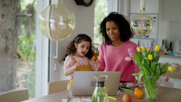 A mother working from home while child is standing next to her. Home office concept.