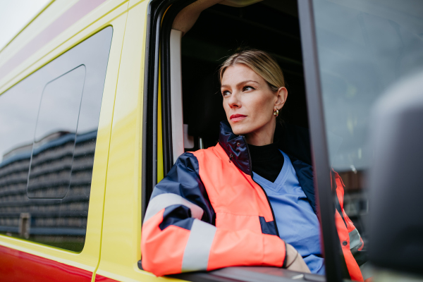 Portrait of young woman doctor sitting in the ambulance car.