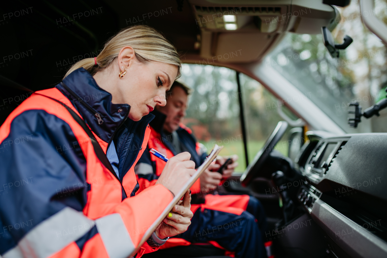 Team of rescuers preparing in an ambulance car to outdoor operation.