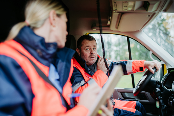 Team of rescuers preparing in an ambulance car to outdoor operation.