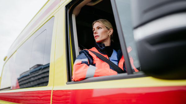 Portrait of young woman doctor sitting in the ambulance car.