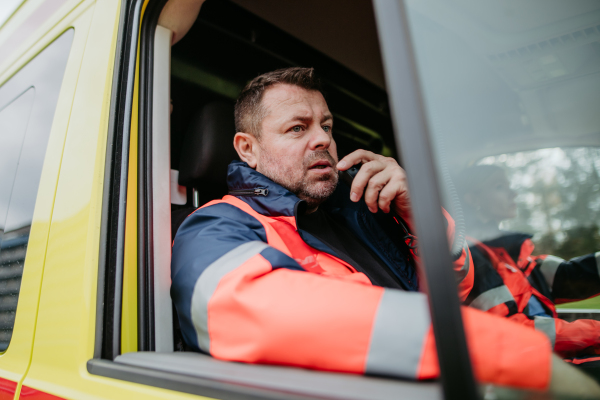 Team of rescuers preparing in an ambulance car to outdoor operation.