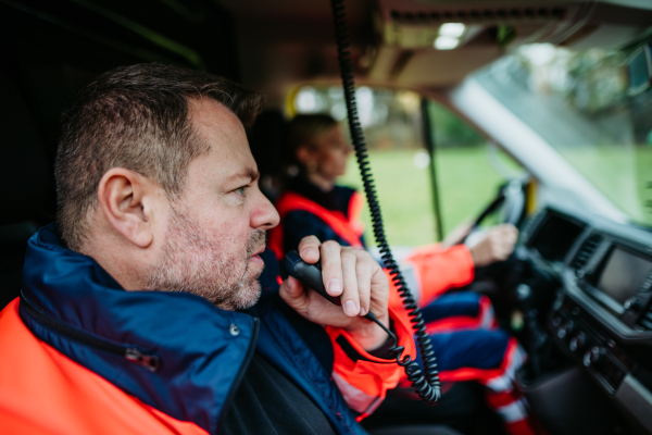 Team of rescuers preparing in an ambulance car to outdoor operation.