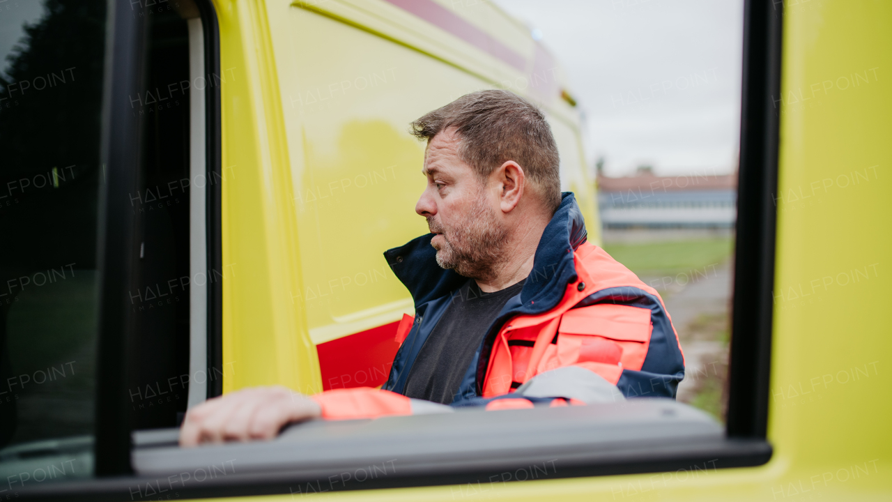 Rescuer getting in to ambulance car, preparing for the rescue operation.