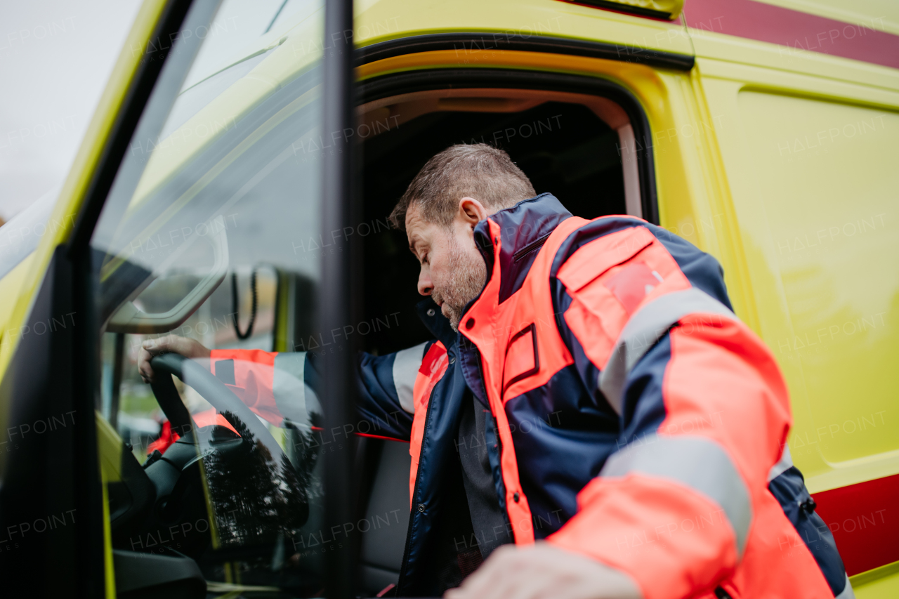 Rescuer getting in to ambulance car, preparing for the rescue operation.