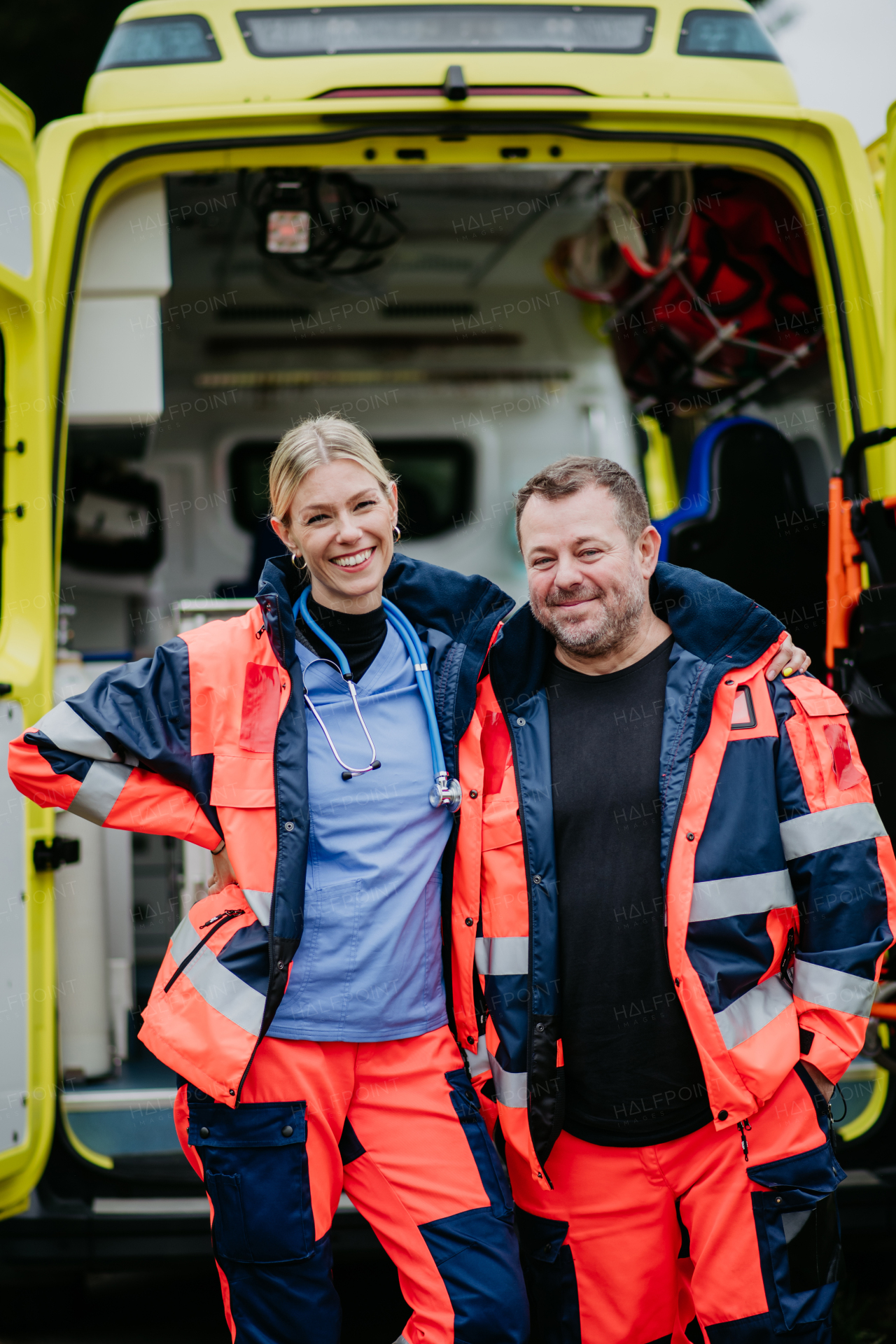 Portrait of rescuers, colleagues in front of ambulance car.