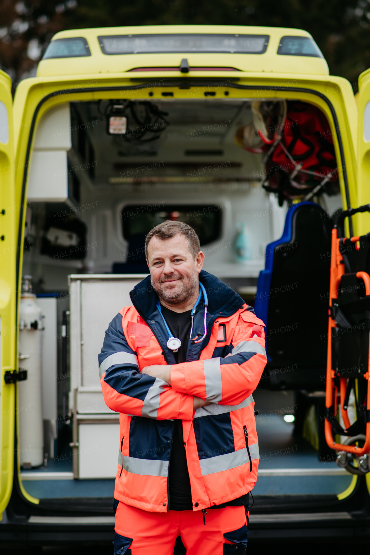 Portrait of rescuer standing in front of ambulance car.