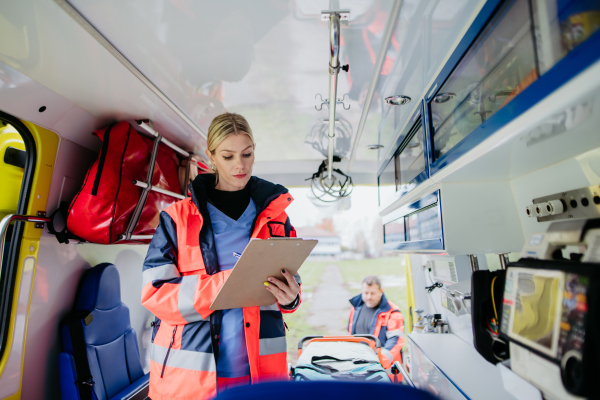 Young rescuer doctor checking equipment in an ambulance car.