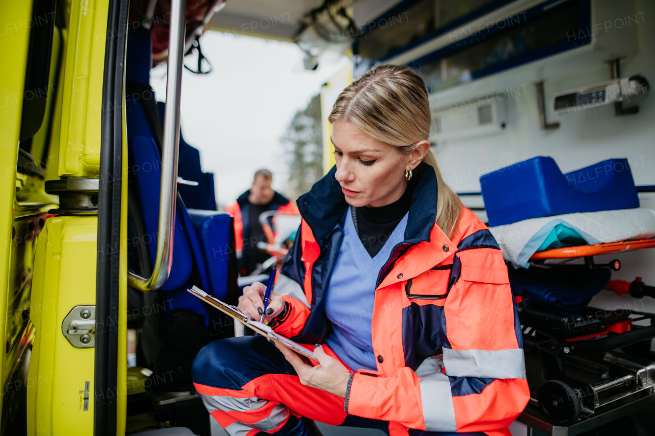 Young rescuer doctor checking equipment in an ambulance car.