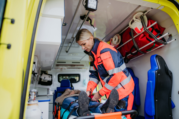 Rescuer taking care of a patient, preparing her for transport.