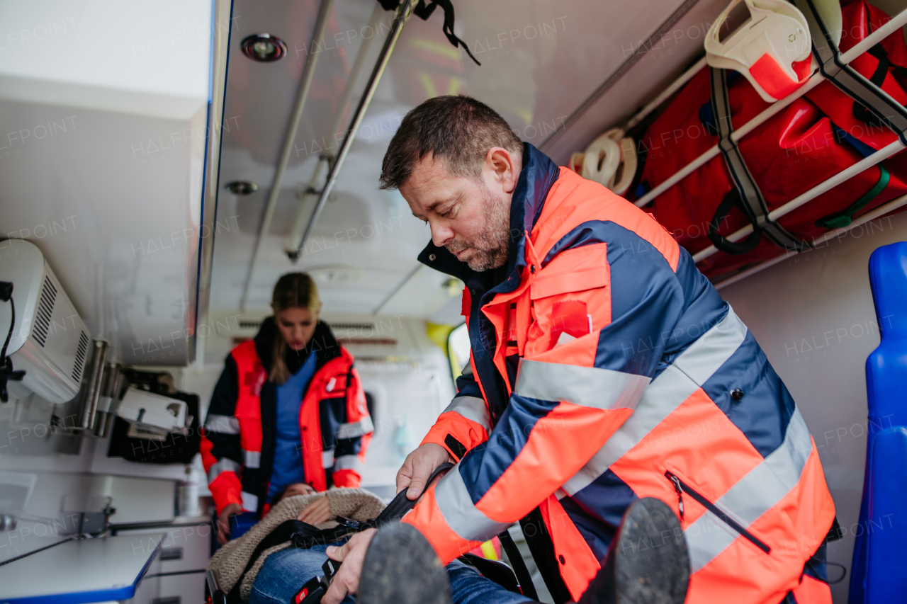 Rescuers taking care of a patient, preparing her for transport.