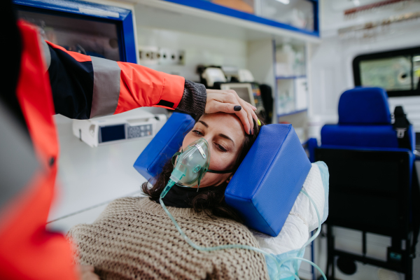 Rescuer taking care of a patient, preparing her for transport.