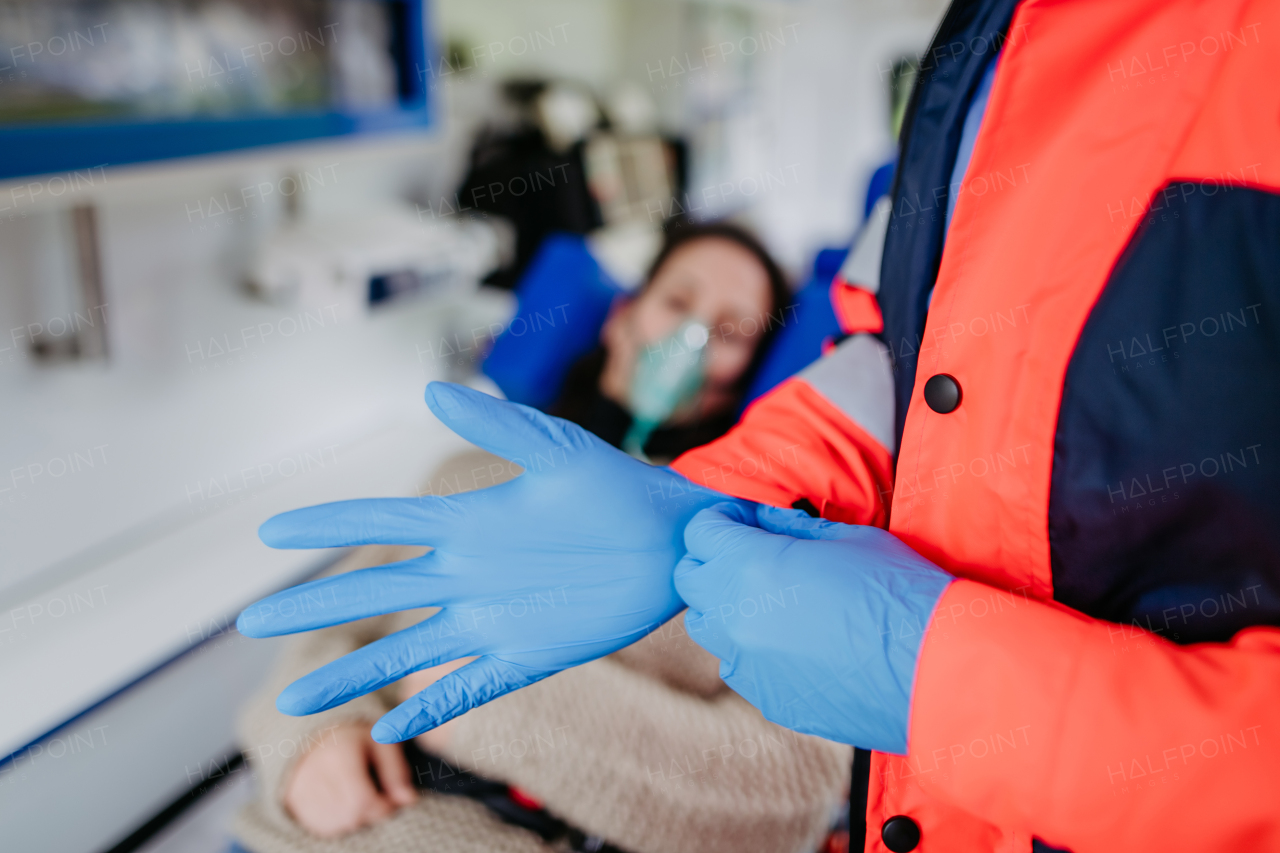 Close-up of a rescuer putting on surgical gloves before examination of patient.