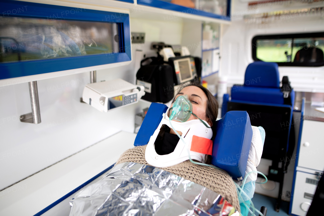 Close-up of woman patient lying in ambulance vehicle after serious accident.