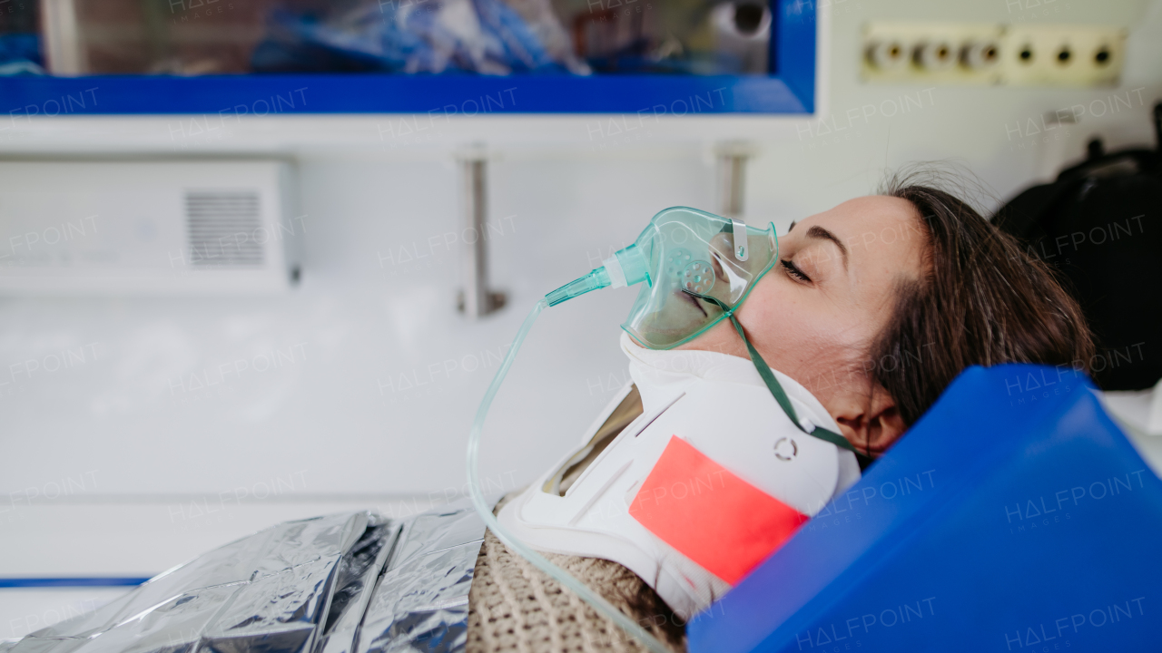 Close-up of woman patient lying in ambulance vehicle after serious accident.