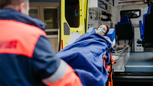 Rescuer taking care of a patient, preparing her for transport.