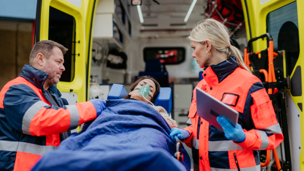 Rescuers taking care of a patient, preparing her for transport.