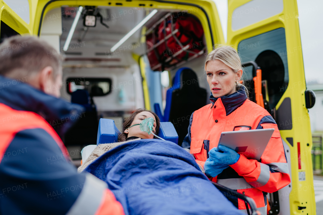 Rescuers taking care of a patient, preparing her for transport.