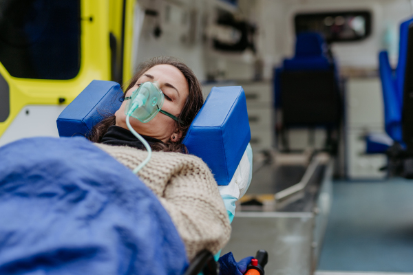 Close-up of woman patient lying in ambulance vehicle after serious accident.