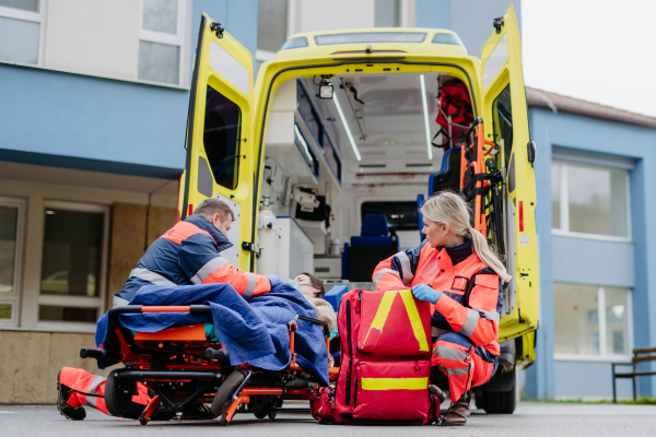 Rescuers taking care of a patient, preparing her for transport.