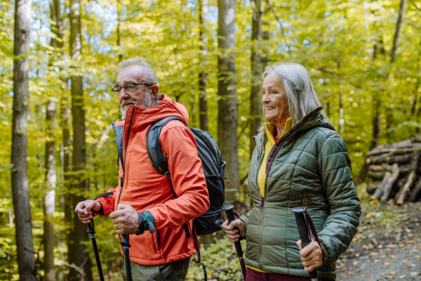 Happy senior couple hiking in autumn nature.