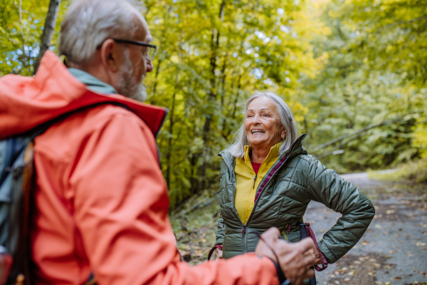 Happy senior couple hiking in autumn nature.