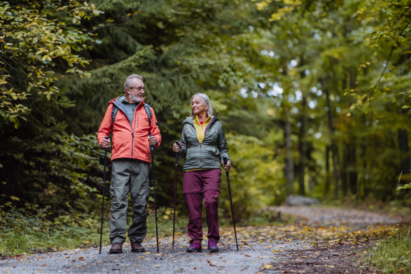 Happy senior couple hiking in autumn nature.