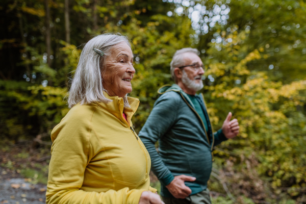 Happy senior couple hiking in autumn nature.