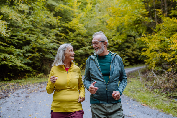 Happy senior couple hiking in autumn nature.