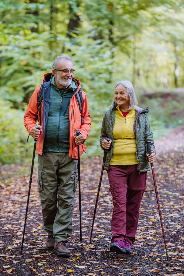 Happy senior couple hiking in autumn nature.