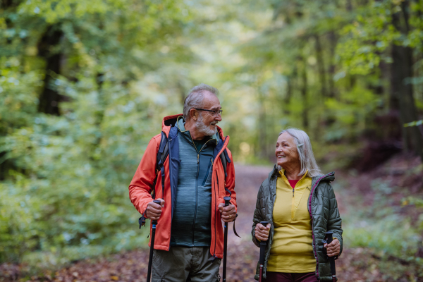 Happy senior couple hiking in autumn nature.