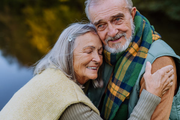 Senior couple in love huging each other in autumn forest.