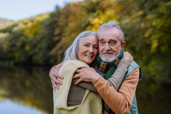 Senior couple in love huging each other in autumn forest.