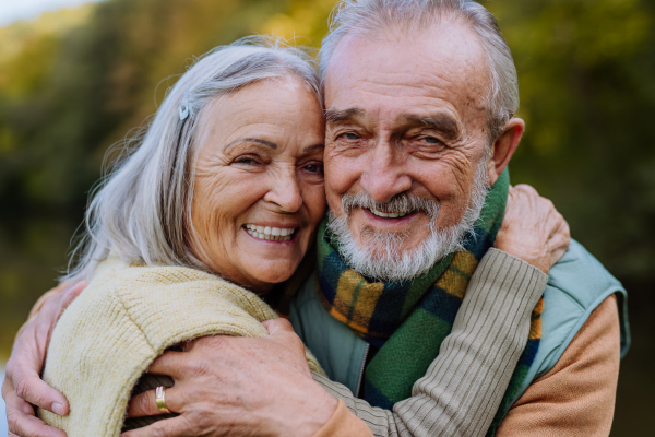 Senior couple in love huging each other in autumn forest.