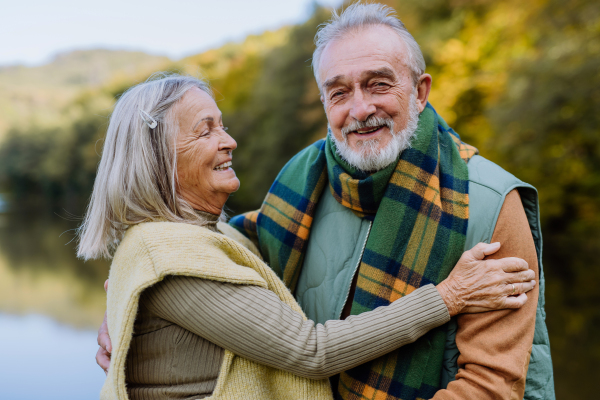 Senior couple in love huging each other in autumn forest.