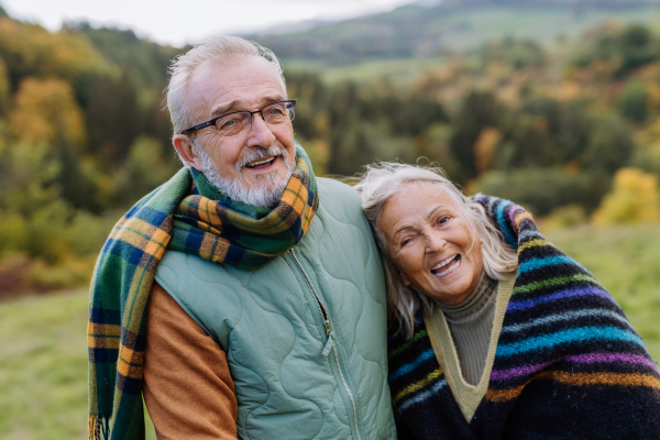 Senior couple in love huging each other in autumn forest.