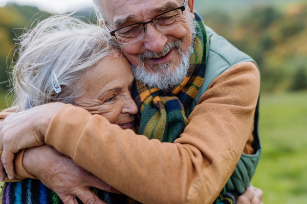 Senior couple in love huging each other in autumn forest.