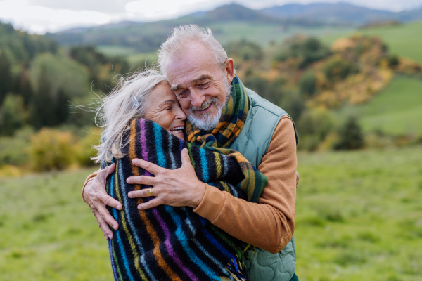 Senior couple in love huging each other in autumn forest.